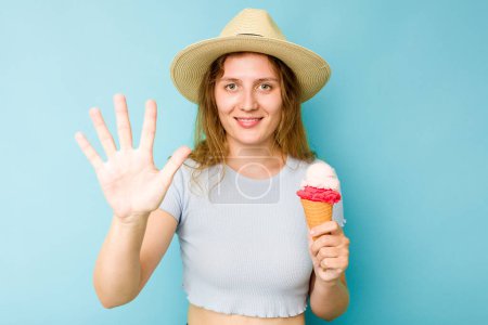 Photo for Young caucasian woman holding an ice cream isolated a blue background smiling cheerful showing number five with fingers. - Royalty Free Image