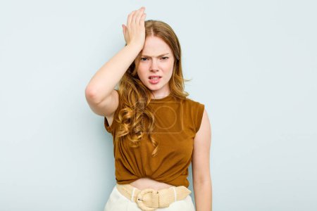 Photo for Young caucasian woman isolated on blue background forgetting something, slapping forehead with palm and closing eyes. - Royalty Free Image