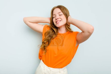 Photo for Young caucasian woman isolated on blue background feeling confident, with hands behind the head. - Royalty Free Image
