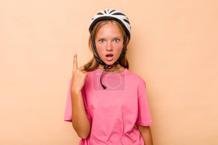 Photo for Little caucasian girl wearing a bike helmet isolated on beige background having some great idea, concept of creativity. - Royalty Free Image
