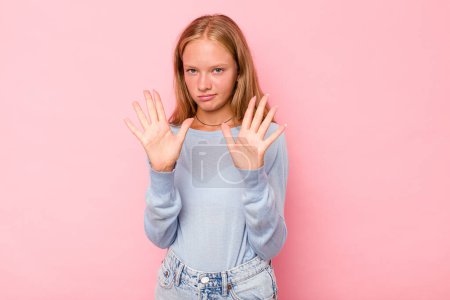 Photo for Caucasian teen girl isolated on pink background standing with outstretched hand showing stop sign, preventing you. - Royalty Free Image