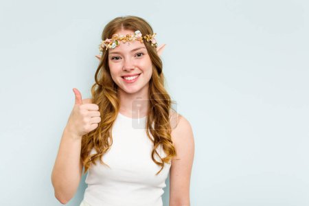 Photo for Young elf woman isolated on blue background smiling and raising thumb up - Royalty Free Image