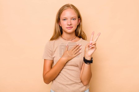 Photo for Caucasian teen girl isolated on beige background taking an oath, putting hand on chest. - Royalty Free Image