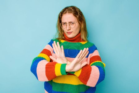 Photo for Young caucasian woman isolated on blue background doing a denial gesture - Royalty Free Image