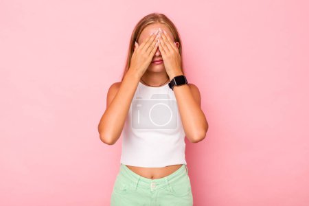 Photo for Caucasian teen girl isolated on pink background afraid covering eyes with hands. - Royalty Free Image