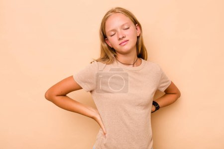 Téléchargez les photos : Caucasien adolescent fille isolé sur beige fond souffrance un mal de dos. - en image libre de droit