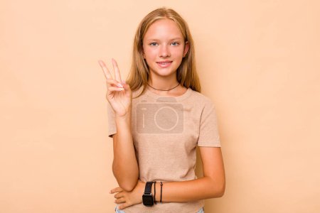 Foto de Caucásico adolescente chica aislado en beige fondo alegre y despreocupado mostrando un símbolo de paz con los dedos. - Imagen libre de derechos
