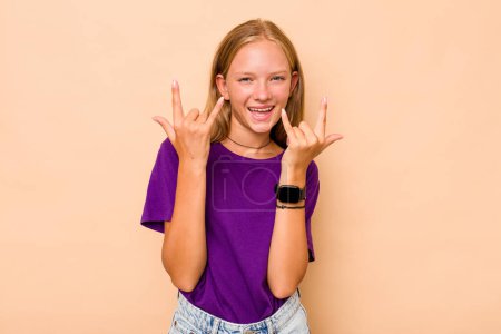 Photo for Caucasian teen girl isolated on beige background showing a horns gesture as a revolution concept. - Royalty Free Image