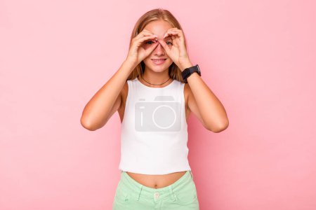 Téléchargez les photos : Caucasien adolescent fille isolé sur fond rose montrant ok signe sur les yeux - en image libre de droit