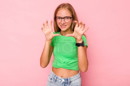 Foto de Caucásico adolescente chica aislado en rosa fondo mostrando garras imitando un gato, gesto agresivo. - Imagen libre de derechos