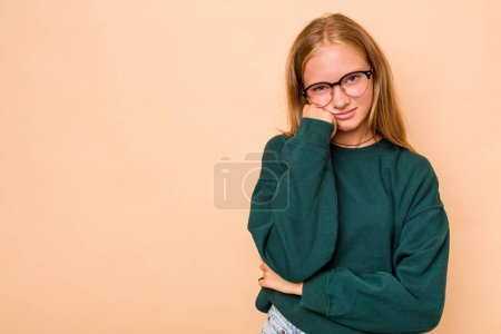 Téléchargez les photos : Caucasien adolescent fille isolé sur fond beige qui se sent triste et onéreux, en regardant l'espace de copie. - en image libre de droit