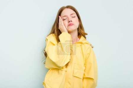 Foto de Mujer joven caucásica aislada sobre fondo azul cansada y muy somnolienta manteniendo la mano en la cabeza. - Imagen libre de derechos