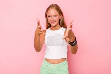 Téléchargez les photos : Caucasien adolescent fille isolé sur fond rose se sent confiant donnant un câlin à la caméra. - en image libre de droit