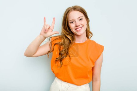 Photo for Young caucasian woman isolated on blue background showing a horns gesture as a revolution concept. - Royalty Free Image