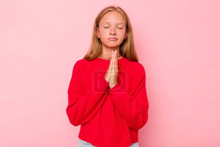 Foto de Caucásico adolescente chica aislado en rosa fondo orando, mostrando devoción, persona religiosa en busca de inspiración divina. - Imagen libre de derechos