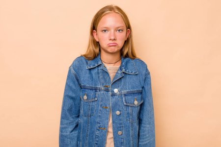 Téléchargez les photos : Caucasien adolescent fille isolé sur beige fond haussements d'épaules et ouvrir les yeux confus. - en image libre de droit