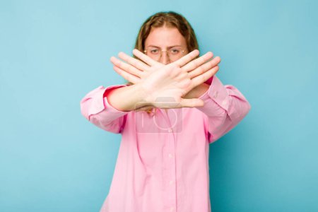 Photo for Young caucasian woman isolated on blue background doing a denial gesture - Royalty Free Image