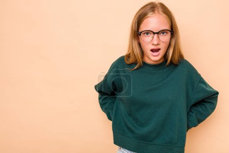 Photo for Caucasian teen girl isolated on beige background being shocked because of something she has seen. - Royalty Free Image
