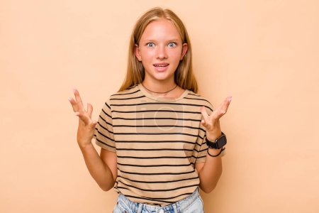 Photo for Caucasian teen girl isolated on beige background screaming to the sky, looking up, frustrated. - Royalty Free Image