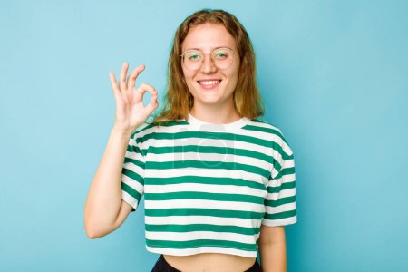 Photo for Young caucasian woman isolated on blue background cheerful and confident showing ok gesture. - Royalty Free Image