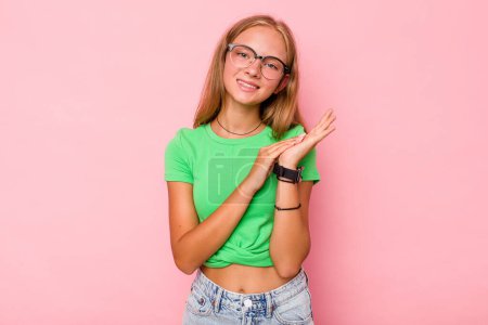 Téléchargez les photos : Caucasien adolescent fille isolé sur fond rose se sentant énergique et confortable, les mains frottantes confiant. - en image libre de droit