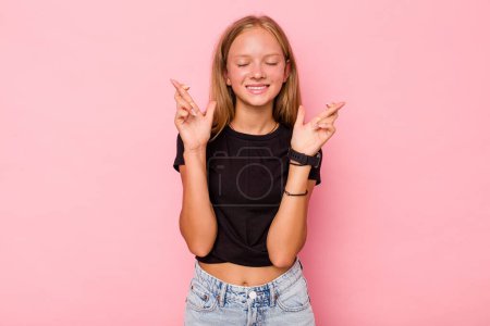 Téléchargez les photos : Caucasien adolescent fille isolé sur fond rose croisement des doigts pour avoir de la chance - en image libre de droit