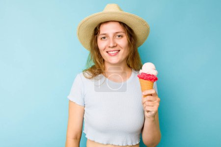 Photo for Young caucasian woman holding an ice cream isolated a blue background happy, smiling and cheerful. - Royalty Free Image