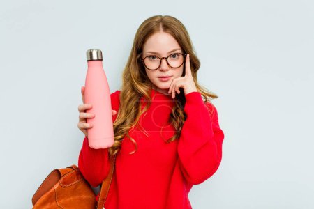 Photo for Young student woman holding a canteen isolated on blue background pointing temple with finger, thinking, focused on a task. - Royalty Free Image