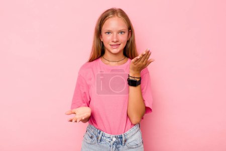 Téléchargez les photos : Caucasien adolescent fille isolé sur fond rose fait échelle avec les bras, se sent heureux et confiant. - en image libre de droit
