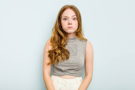 Photo for Young caucasian woman isolated on blue background shrugs shoulders and open eyes confused. - Royalty Free Image