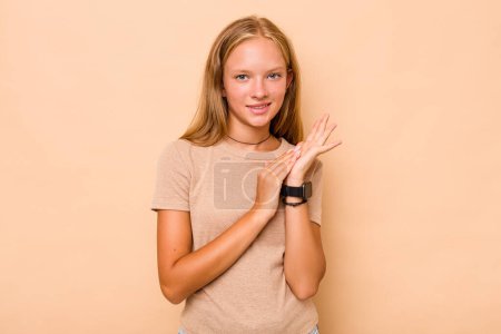 Téléchargez les photos : Caucasien adolescent fille isolé sur beige fond sentiment énergique et confortable, frottement mains confiant. - en image libre de droit