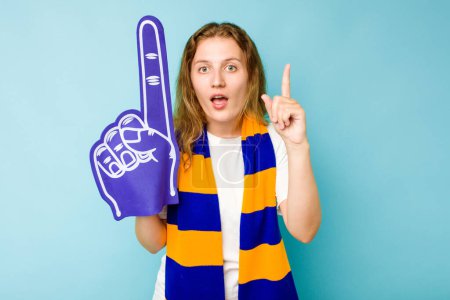 Téléchargez les photos : Jeune fan de sport caucasien femme isolée sur fond bleu ayant une idée, concept d'inspiration. - en image libre de droit