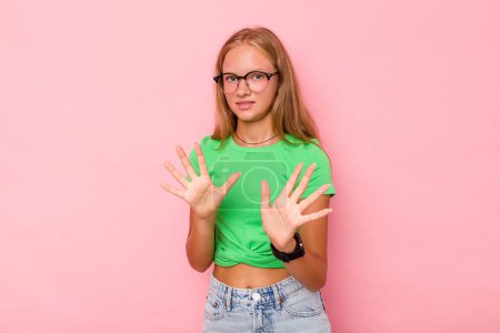 Photo for Caucasian teen girl isolated on pink background rejecting someone showing a gesture of disgust. - Royalty Free Image
