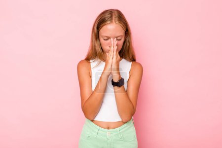 Foto de Caucásico adolescente chica aislado en rosa fondo orando, mostrando devoción, persona religiosa en busca de inspiración divina. - Imagen libre de derechos