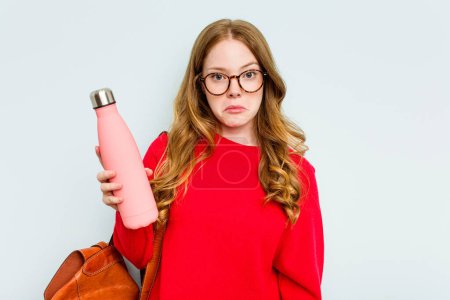 Photo for Young student woman holding a canteen isolated on blue background shrugs shoulders and open eyes confused. - Royalty Free Image