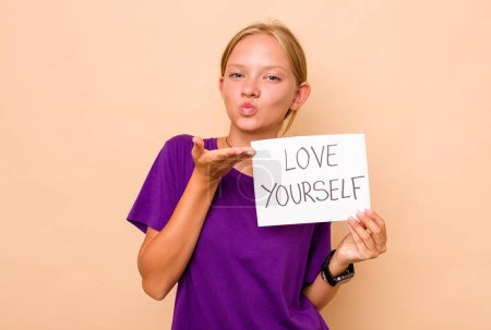 Foto de Pequeña mujer caucásica sosteniendo amor usted mismo cartel aislado sobre fondo beige - Imagen libre de derechos