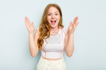 Photo for Young caucasian woman isolated on blue background receiving a pleasant surprise, excited and raising hands. - Royalty Free Image