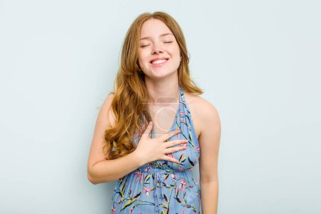Photo for Young caucasian woman isolated on blue background laughs out loudly keeping hand on chest. - Royalty Free Image