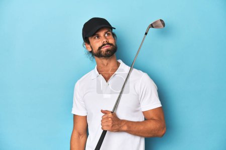 Foto de Golfista de pelo largo con club y sombrero soñando con alcanzar metas y propósitos - Imagen libre de derechos