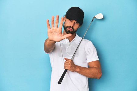 Photo for Long-haired golfer with club and hat standing with outstretched hand showing stop sign, preventing you. - Royalty Free Image