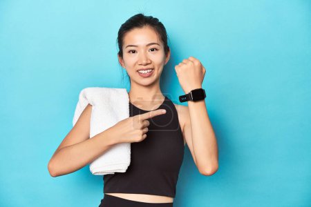 Photo for Sportswoman showing smartwatch feature, studio backdrop. - Royalty Free Image