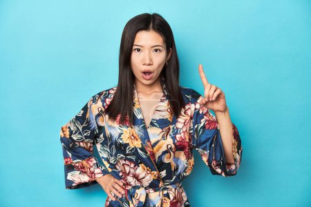Téléchargez les photos : Élégante jeune femme asiatique en kimono, plan studio ayant une idée, concept d'inspiration. - en image libre de droit