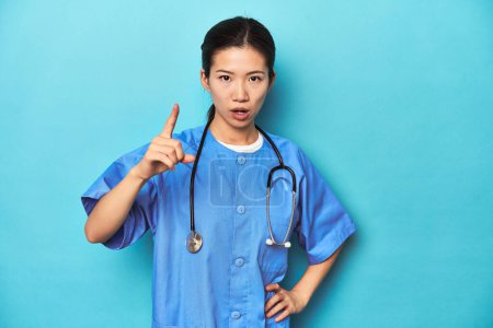 Téléchargez les photos : Infirmière asiatique avec stéthoscope, studio médical tourné, ayant une idée, concept d'inspiration. - en image libre de droit