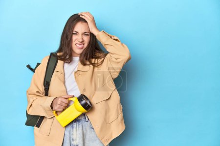 Photo for Adventurous woman with flashlight and backpack ready to explore being shocked, she has remembered important meeting. - Royalty Free Image