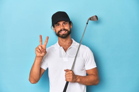 Foto de Golfista de pelo largo con club y sombrero mostrando el número dos con los dedos. - Imagen libre de derechos