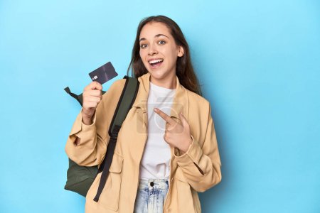 Foto de Mujer viajero joven con mochila y tarjeta de crédito en azul. - Imagen libre de derechos