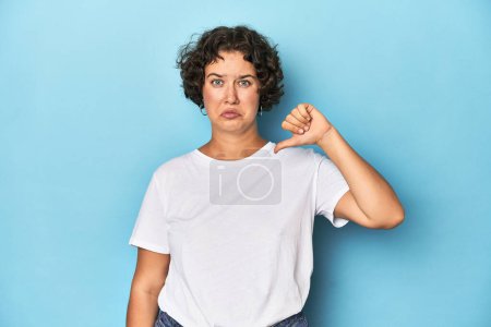 Photo for Young Caucasian woman with short hair showing a dislike gesture, thumbs down. Disagreement concept. - Royalty Free Image