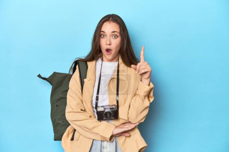 Photo for Young Caucasian woman traveler with camera and backpack having some great idea, concept of creativity. - Royalty Free Image