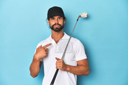 Téléchargez les photos : Golfeur aux cheveux longs avec club et chapeau pointant vers le côté - en image libre de droit