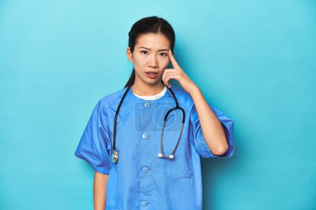 Photo for Asian nurse with stethoscope, medical studio shot, showing a disappointment gesture with forefinger. - Royalty Free Image